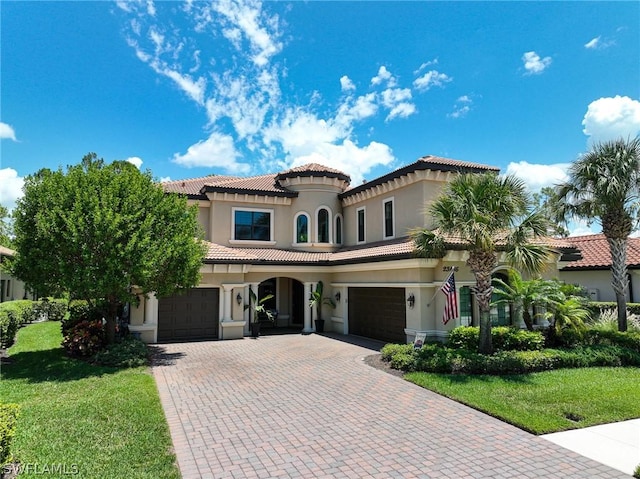 mediterranean / spanish-style home featuring a garage and a front yard