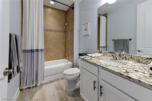 full bathroom with shower / tub combo, vanity, hardwood / wood-style flooring, and toilet