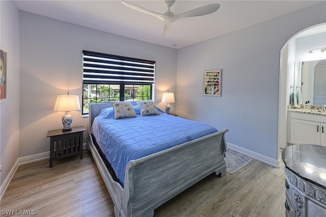 bedroom featuring ceiling fan, light hardwood / wood-style flooring, and ensuite bath