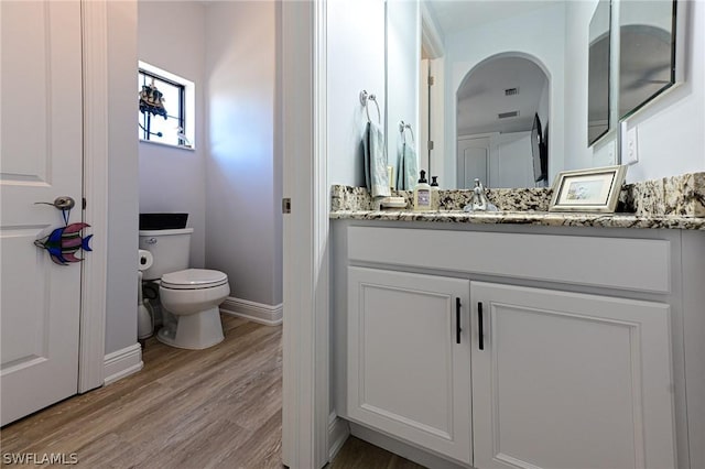 bathroom featuring vanity, hardwood / wood-style flooring, and toilet