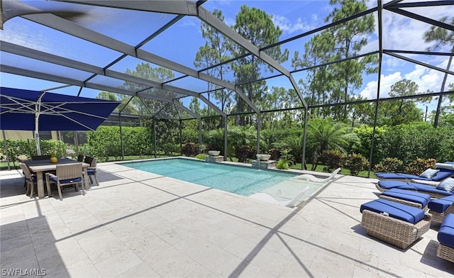 view of pool featuring glass enclosure and a patio area