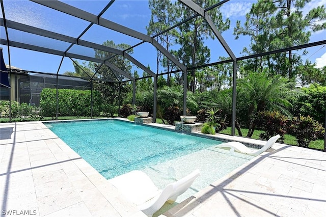 view of pool with glass enclosure and a patio area