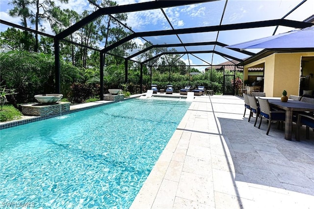 view of pool featuring pool water feature, glass enclosure, and a patio area