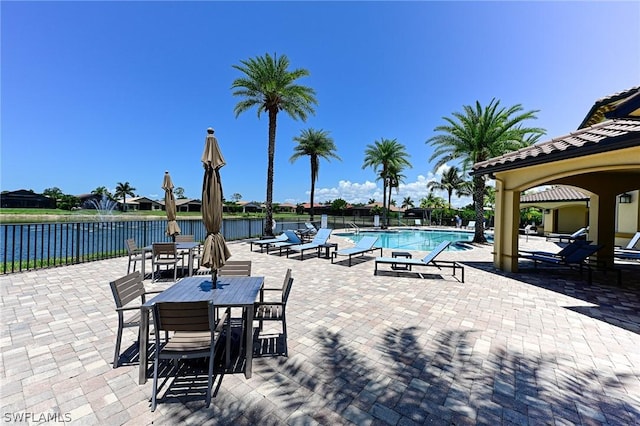 view of swimming pool featuring a water view and a patio