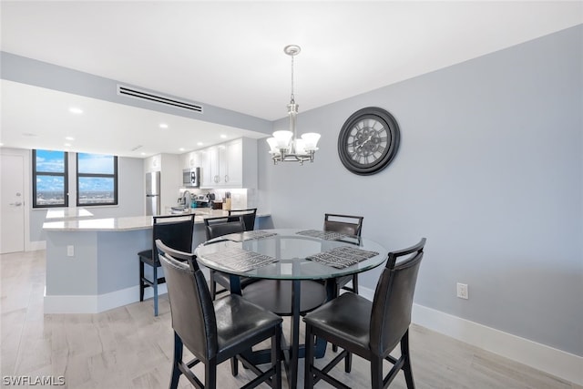 dining area featuring a notable chandelier and light hardwood / wood-style floors