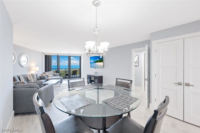 dining area with light hardwood / wood-style flooring and a notable chandelier