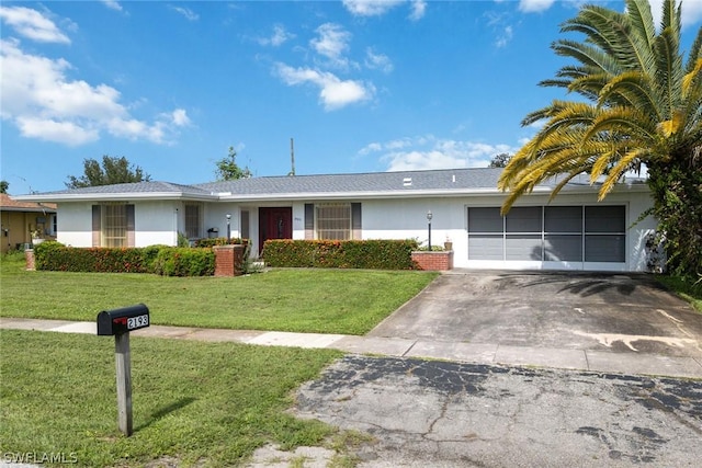 ranch-style home with a garage and a front lawn