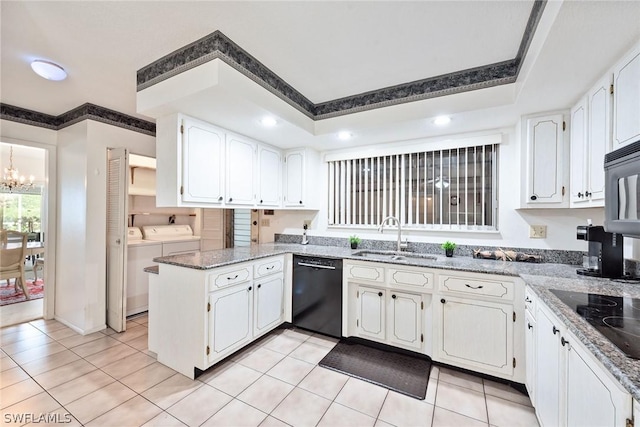 kitchen with black appliances, washing machine and dryer, white cabinetry, sink, and kitchen peninsula