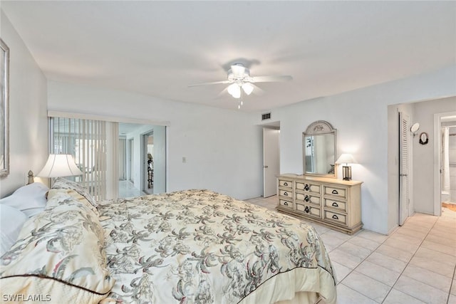 bedroom with ceiling fan, light tile patterned flooring, and connected bathroom