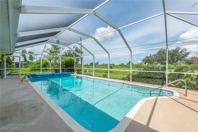 view of swimming pool with glass enclosure and a patio