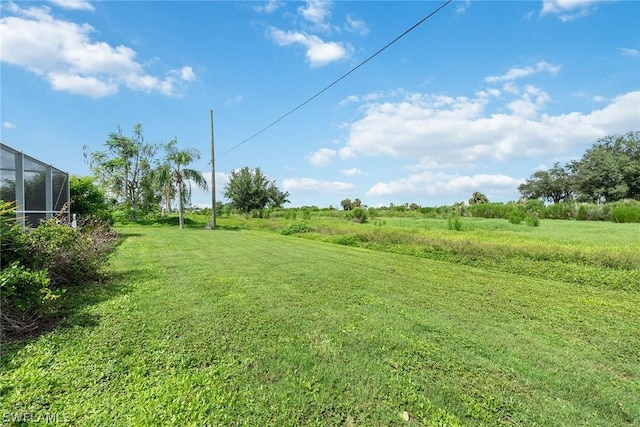 view of yard with a rural view and glass enclosure