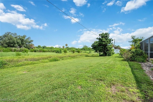 view of yard featuring a lanai and a rural view