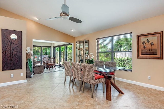 tiled dining space featuring ceiling fan and vaulted ceiling