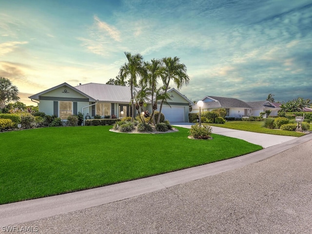 single story home with a lawn and a garage