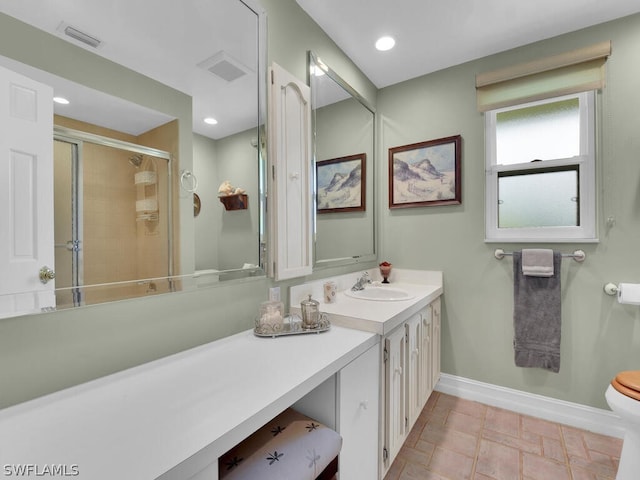 bathroom featuring tile patterned flooring, a shower with door, vanity, and toilet