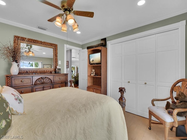 bedroom featuring a closet, light hardwood / wood-style flooring, ceiling fan, and ornamental molding