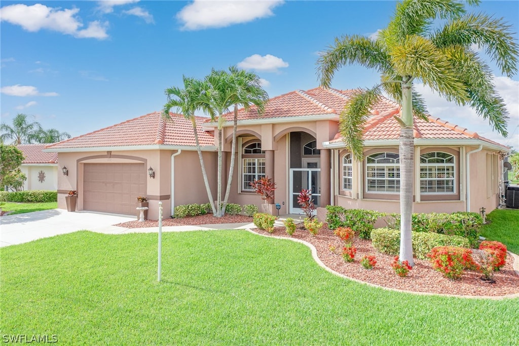 mediterranean / spanish house featuring cooling unit, a garage, and a front yard