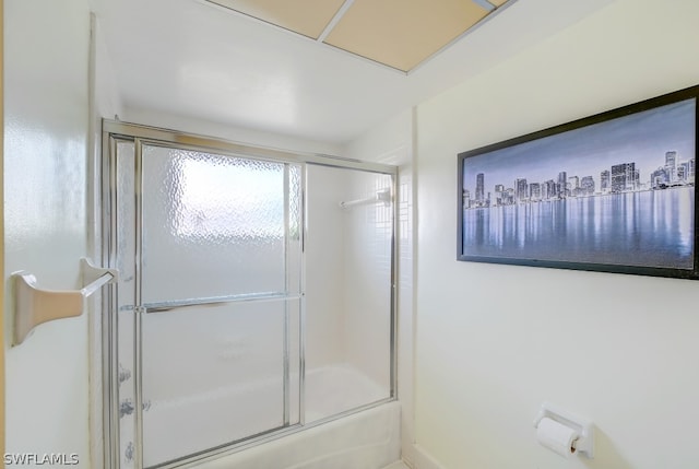 bathroom featuring combined bath / shower with glass door