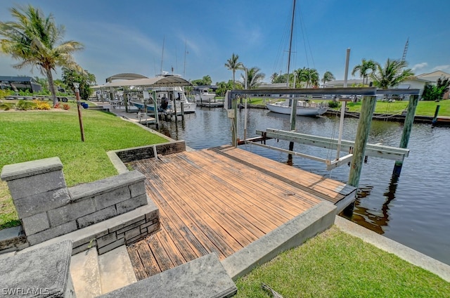 view of dock with a water view and a lawn