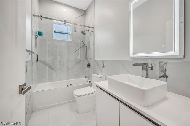 full bathroom featuring tile floors, tile walls, vanity with extensive cabinet space, tiled shower / bath combo, and toilet