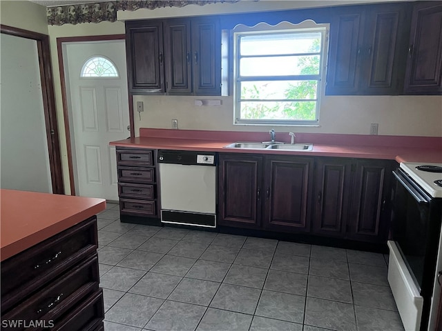 kitchen featuring dark brown cabinetry, sink, white appliances, and light tile floors