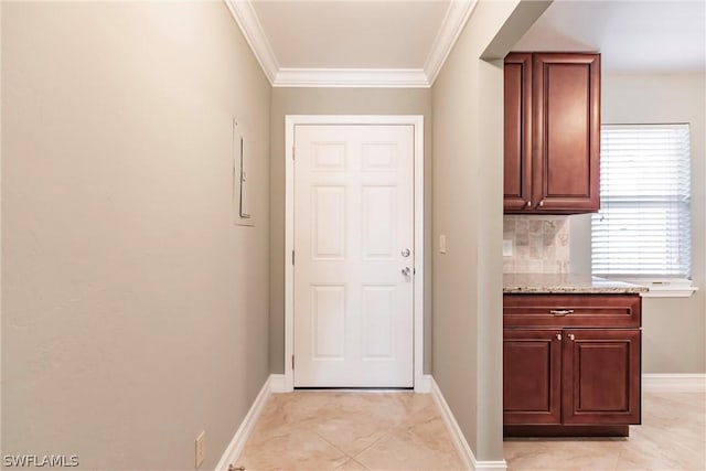 entryway with ornamental molding and light tile floors