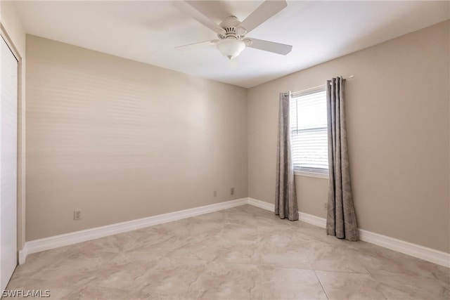 spare room with ceiling fan and light tile floors