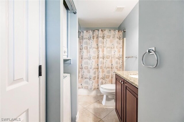 bathroom with tile flooring, washer / dryer, vanity, and toilet