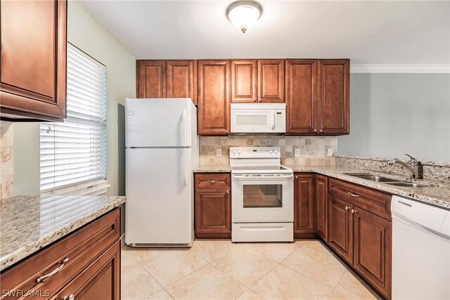 kitchen with light stone countertops, sink, white appliances, and light tile floors