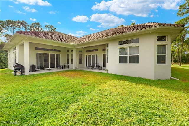 back of house featuring a lawn and a patio area