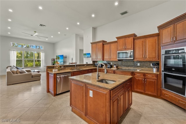 kitchen featuring sink, appliances with stainless steel finishes, a center island with sink, and kitchen peninsula