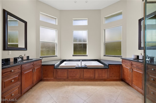 bathroom featuring a tub to relax in, vanity, and tile patterned floors