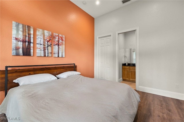 bedroom featuring high vaulted ceiling, ensuite bathroom, and dark hardwood / wood-style flooring