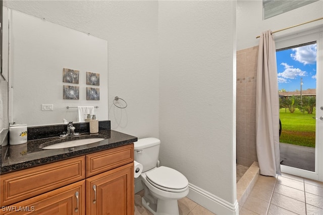 bathroom featuring toilet, a shower with shower curtain, tile patterned floors, and vanity