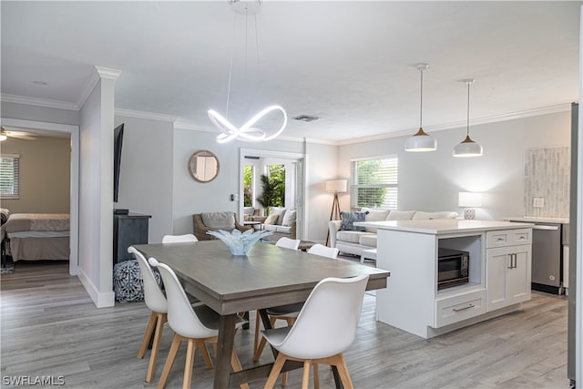 dining space featuring light hardwood / wood-style floors, ceiling fan with notable chandelier, and crown molding