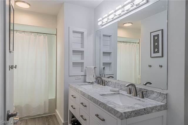 bathroom with hardwood / wood-style flooring and double sink vanity