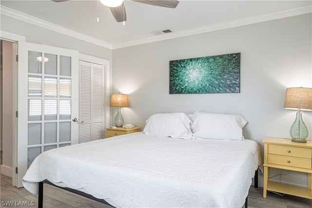 bedroom featuring crown molding, a closet, wood-type flooring, and ceiling fan