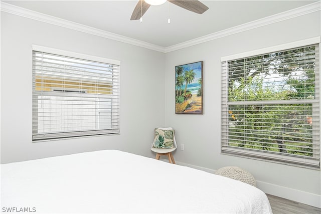 bedroom with crown molding, hardwood / wood-style floors, multiple windows, and ceiling fan