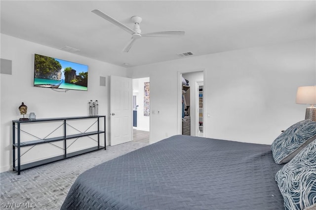 bedroom featuring ceiling fan, light carpet, visible vents, baseboards, and a spacious closet