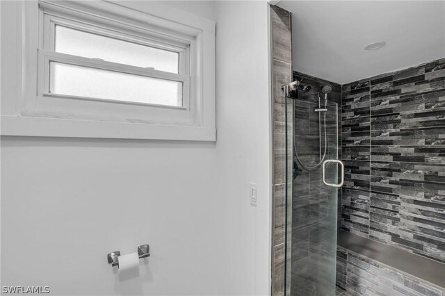 bathroom featuring a shower with shower door