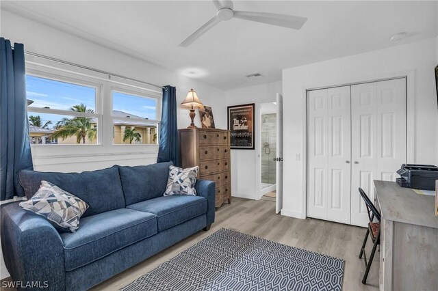 living room featuring ceiling fan and light hardwood / wood-style flooring