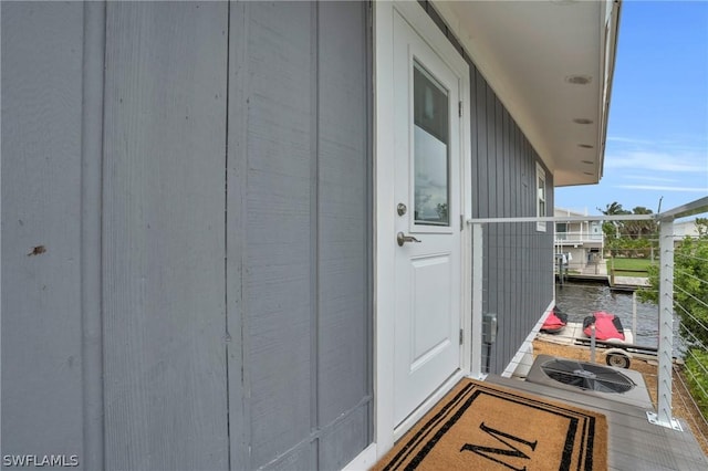 entrance to property with a water view and a balcony