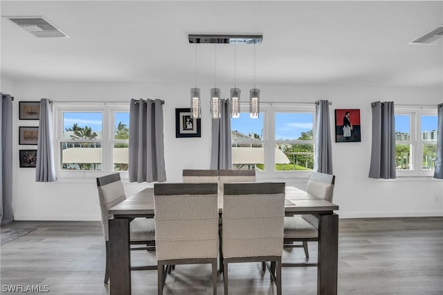 dining space featuring visible vents, plenty of natural light, and wood finished floors