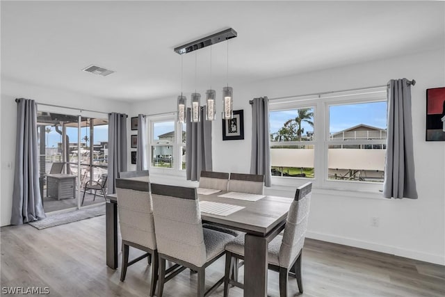 dining area featuring hardwood / wood-style flooring and an inviting chandelier