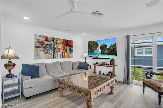 living room featuring light wood-type flooring, ceiling fan, visible vents, and recessed lighting