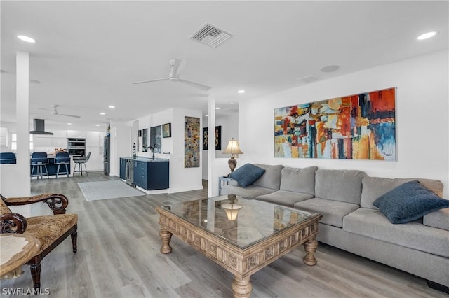 living room with recessed lighting, visible vents, ceiling fan, and light wood finished floors