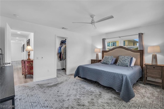 bedroom featuring visible vents, baseboards, a ceiling fan, a walk in closet, and a closet