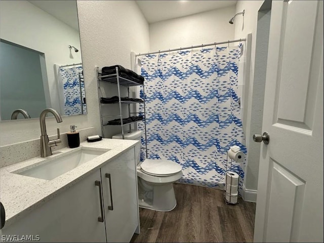 bathroom with hardwood / wood-style flooring, vanity, toilet, and walk in shower