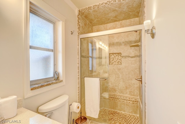 bathroom with a shower with shower door and toilet