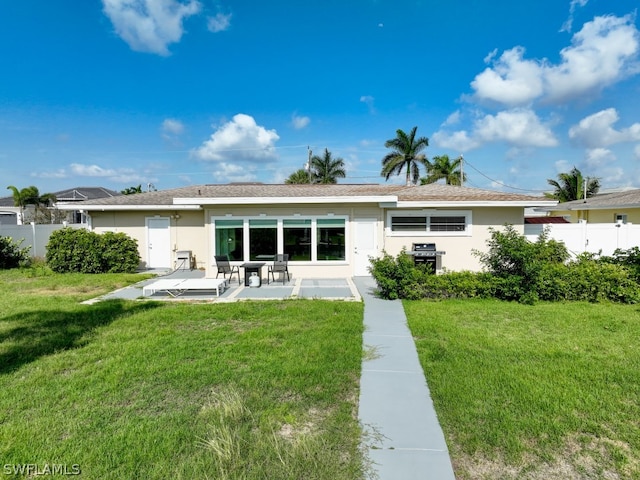 rear view of house featuring a yard and a patio area